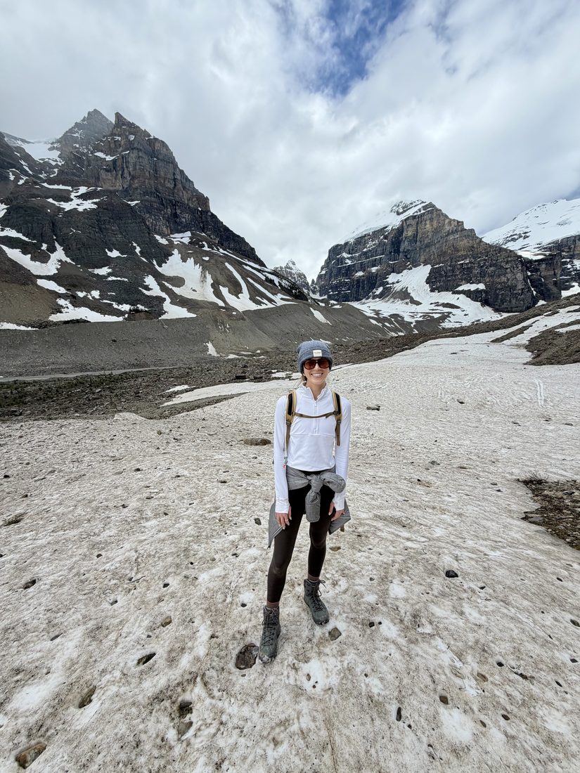 Cayce Smith standing on a snowy mountain trail, smiling.