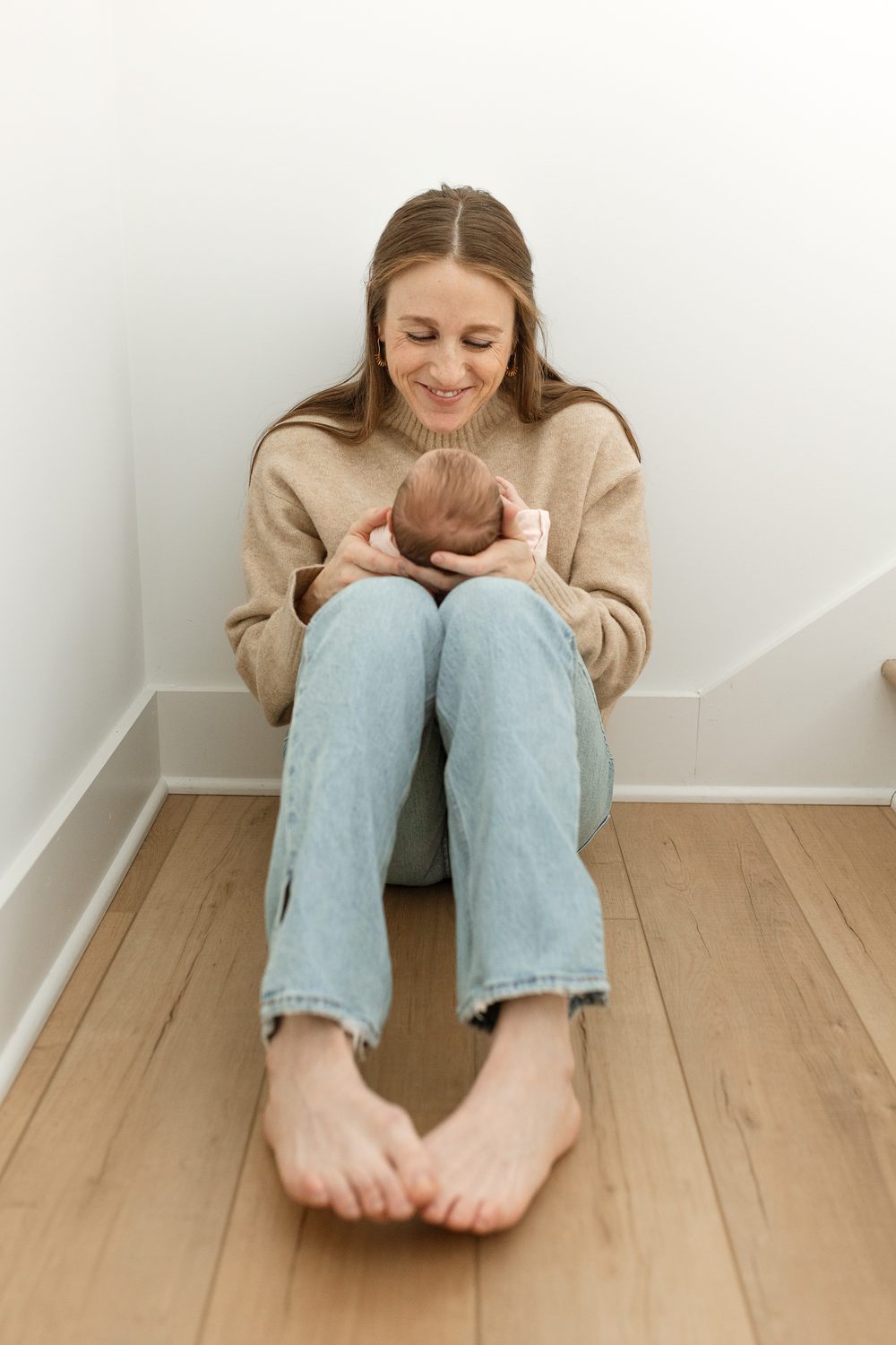 Jess Mansell smiling while holding her newborn daughter.