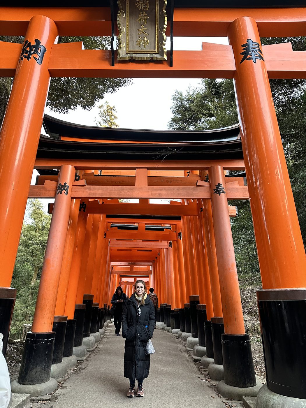 Jess Mansell walking beneath the orange torii gates at Fushimi Inari Shrine in Kyoto, Japan.